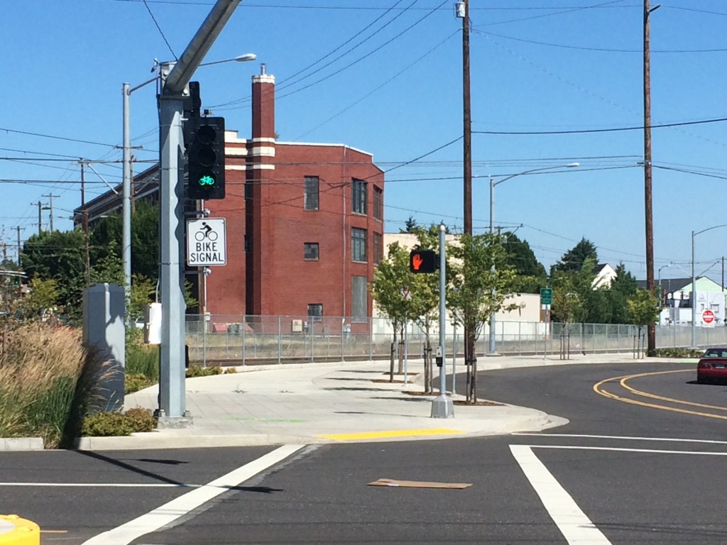 The crossing at SE 8th Ave showing a green bicycle signal but a red hand pedestrian signal.